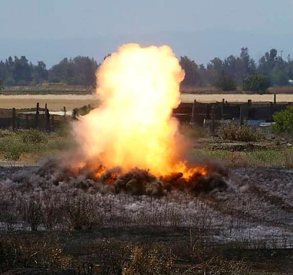 small explosion/fire in a field