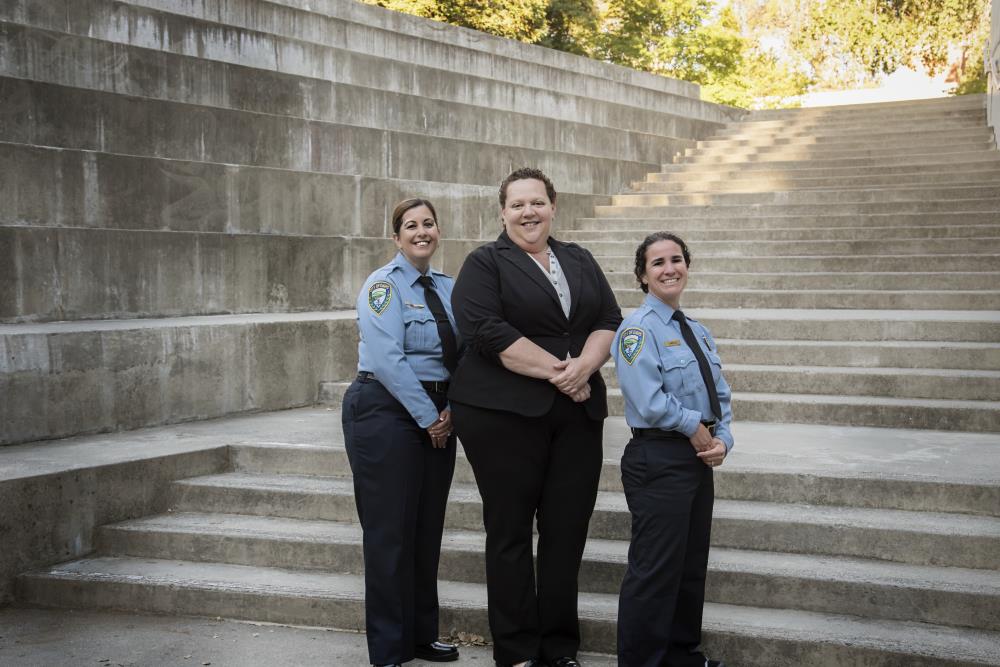 Three staff members posing in uniform